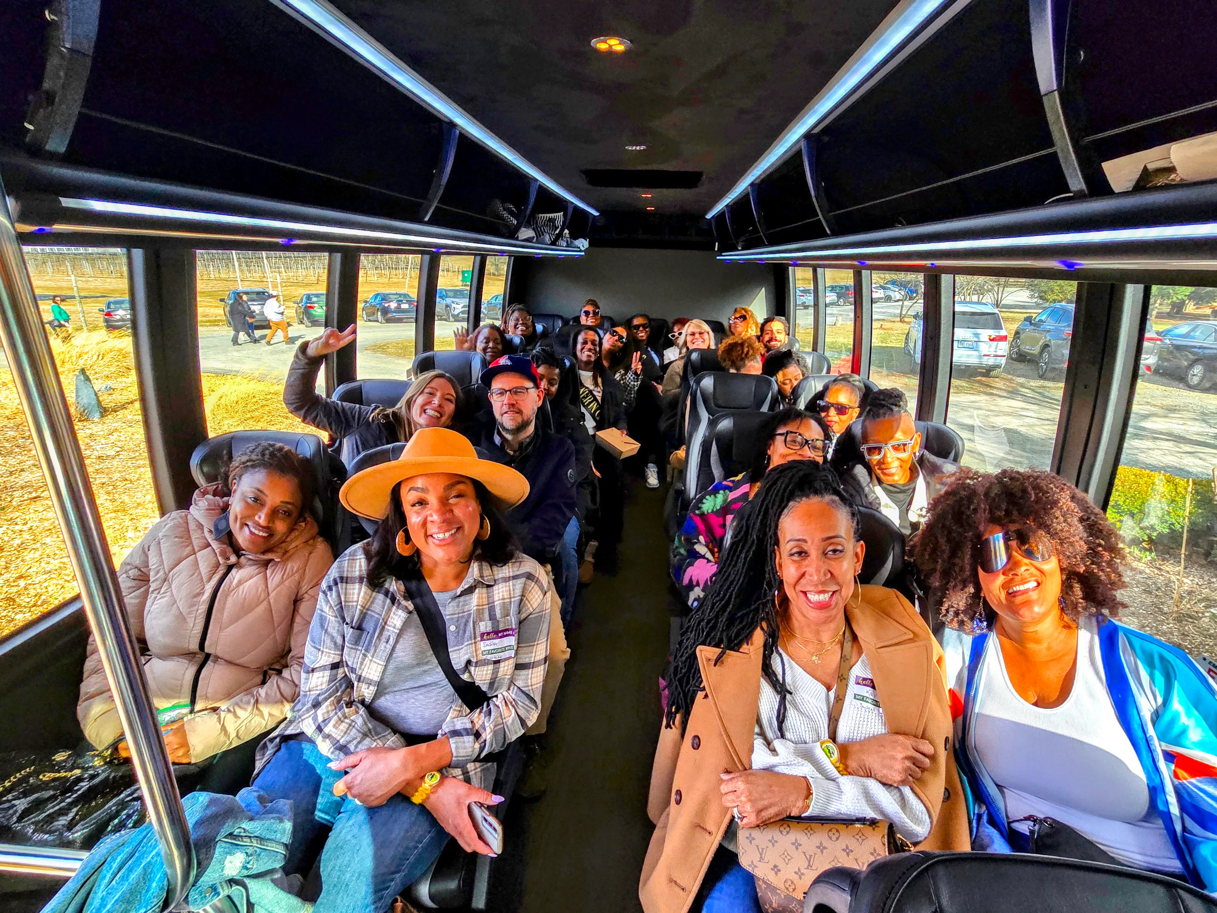 Guests smiling together inside the Vineyard Voyages executive bus
