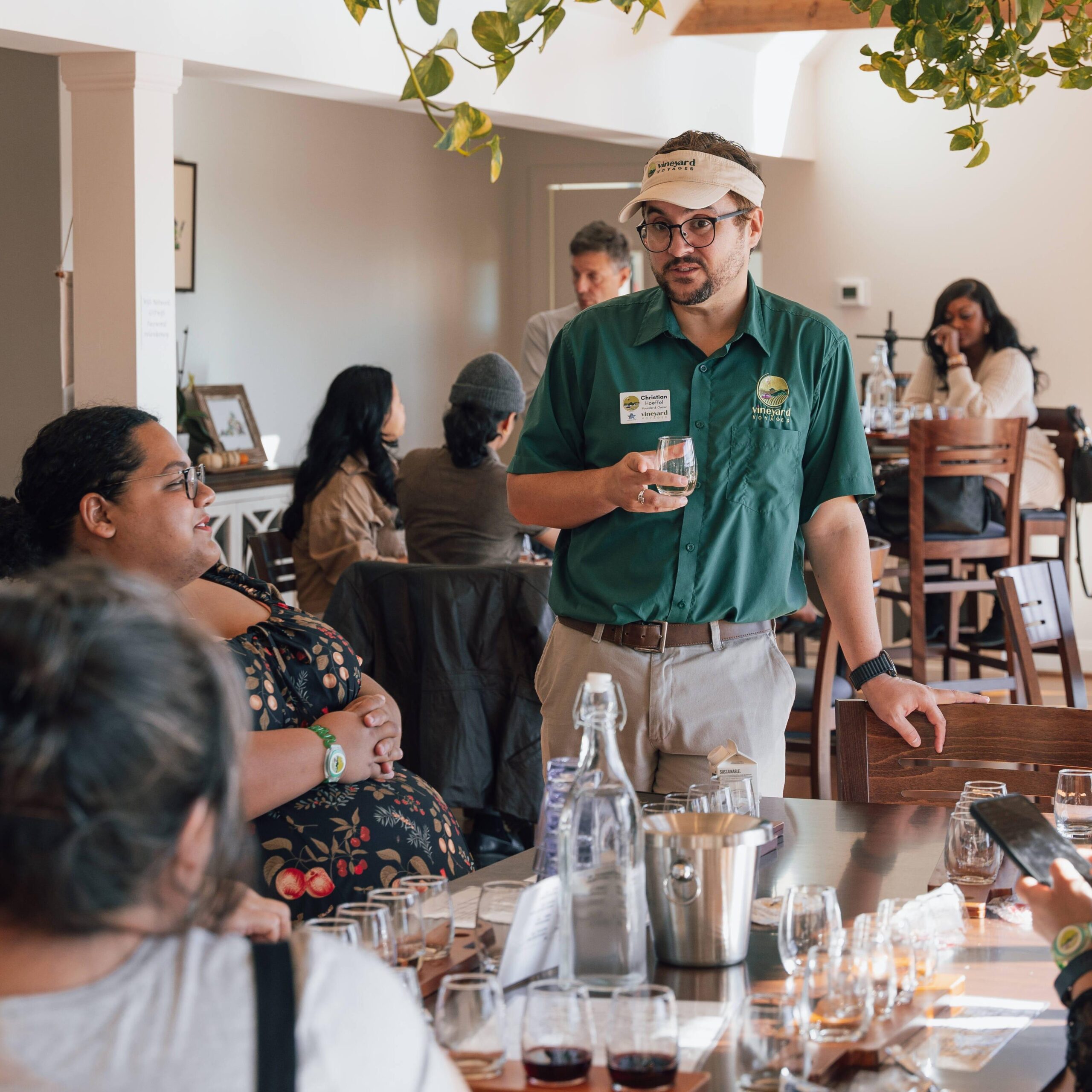A Vineyard Voyages guide speaking with guests during a winery tasting