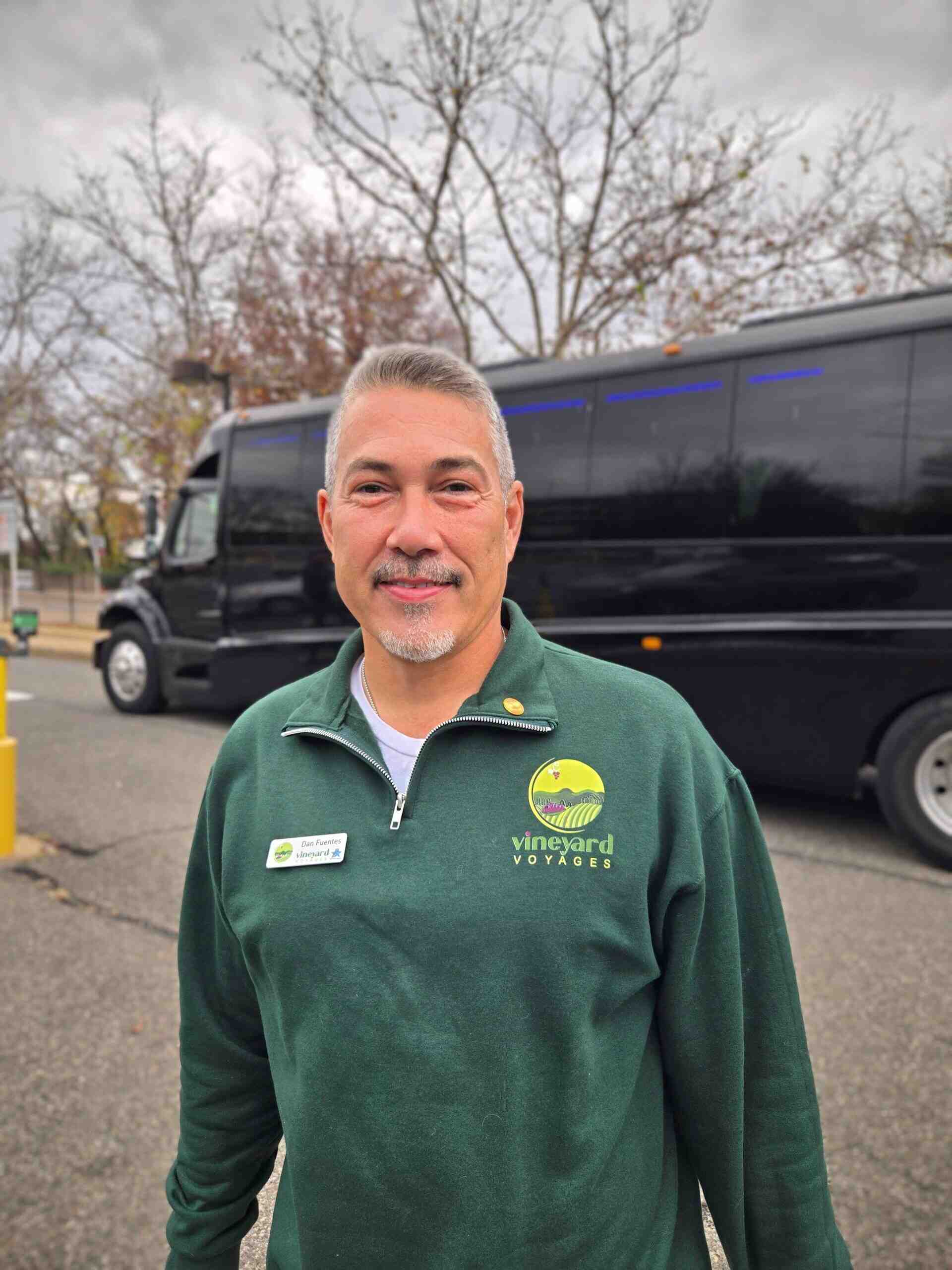 Dan Fuentes, Vineyard Voyages tour guide, standing beside the executive bus