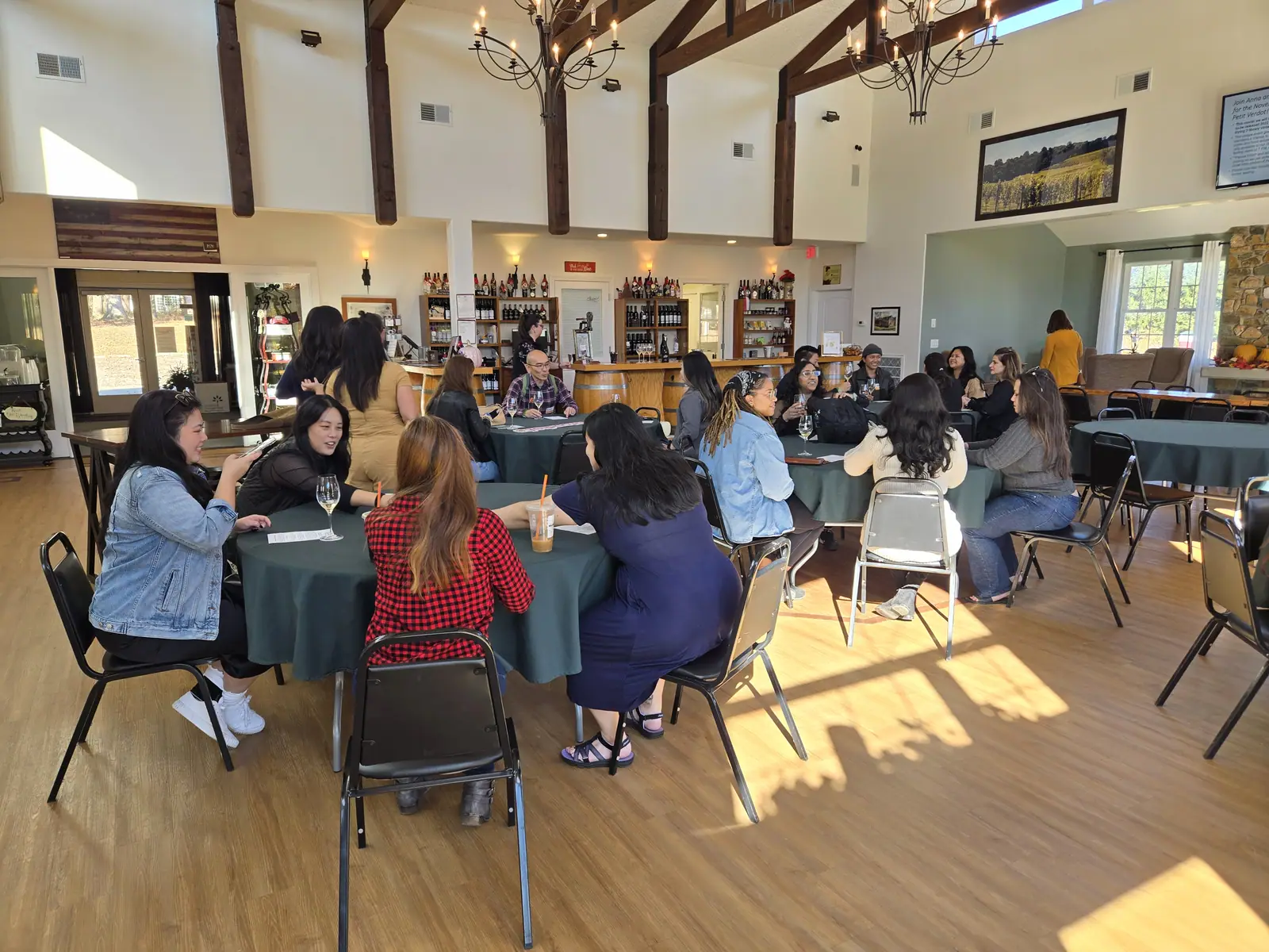A large corporate group seated at long tables in a winery event room