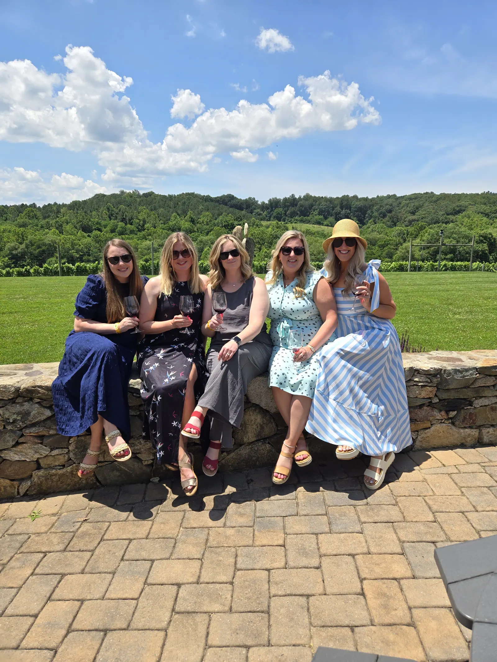 Friends seated on a stone wall with the hills behind them