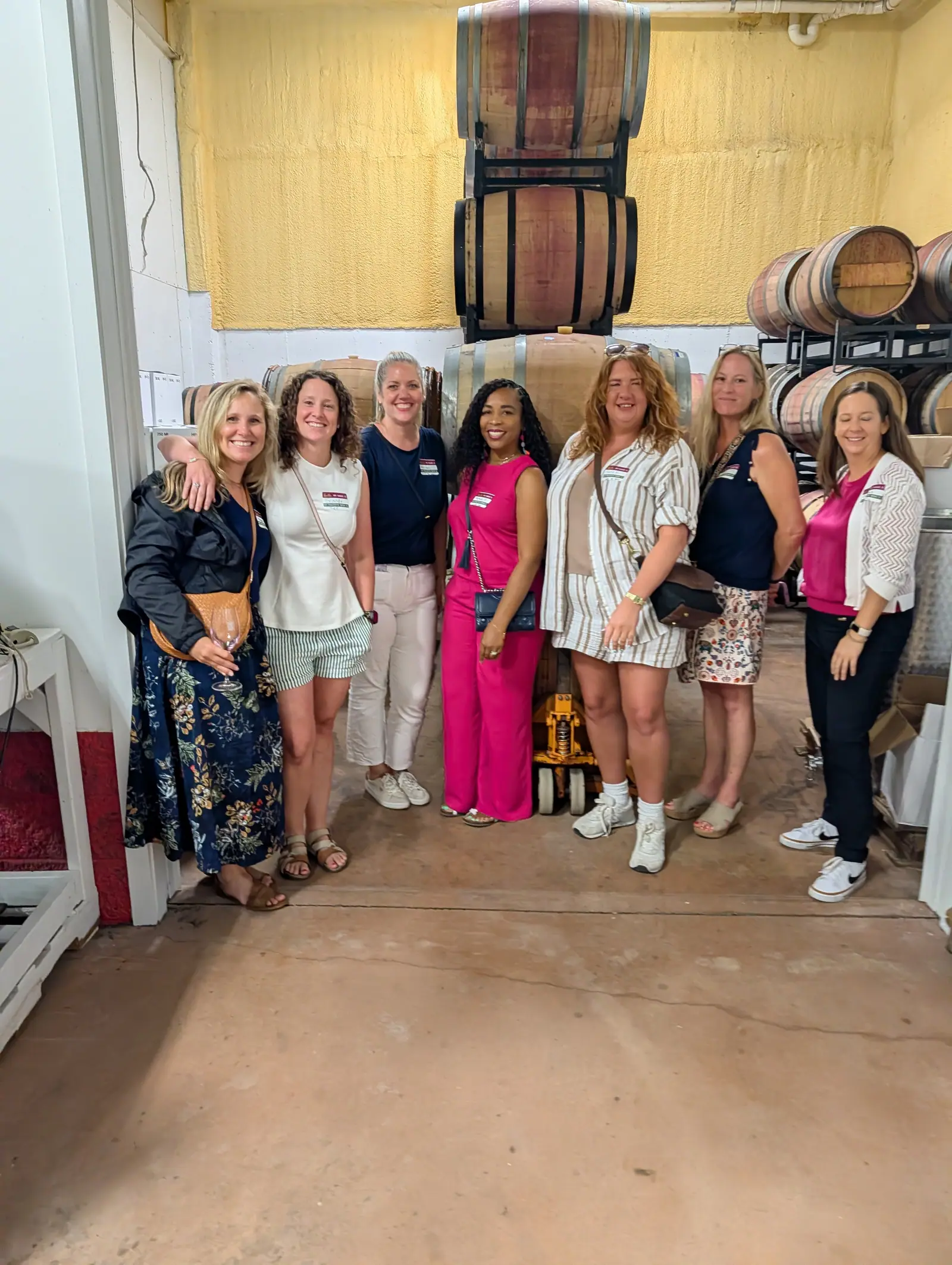 A tour group standing together in a winery barrel room