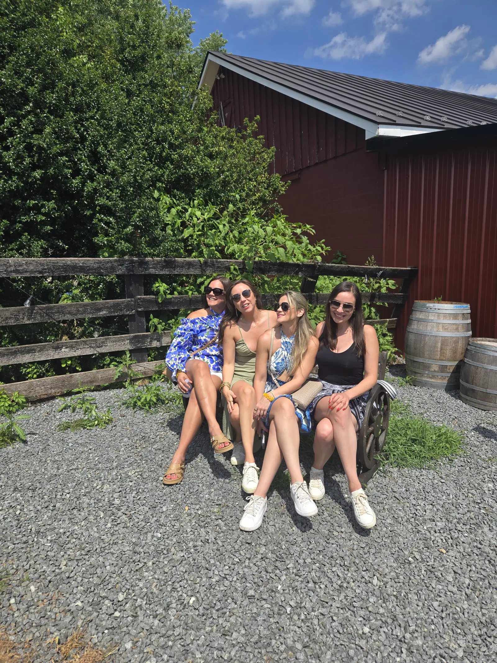 A celebration group seated together outside a red winery barn