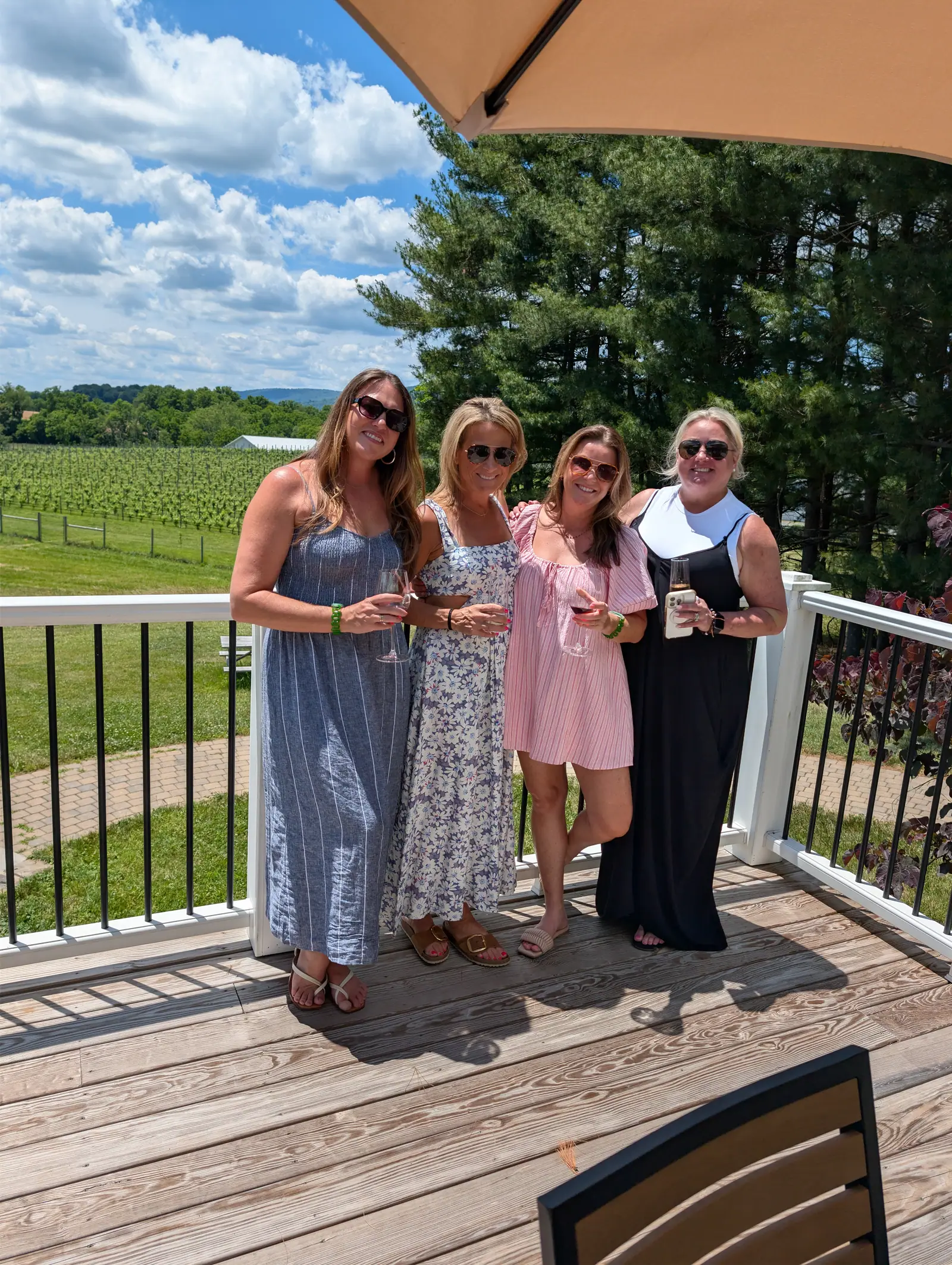 A bachelorette group posed together on a winery deck