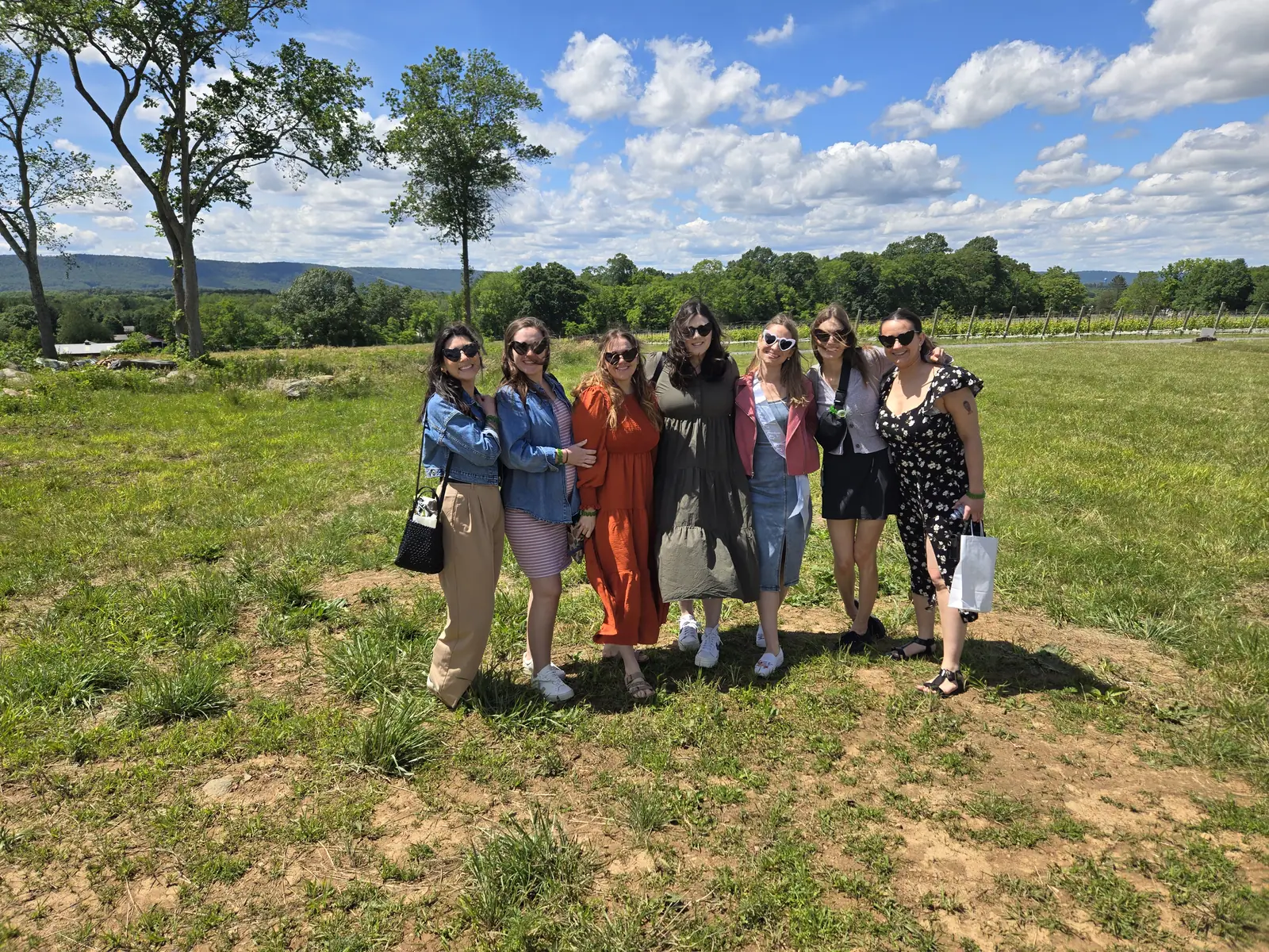 A group of guests standing among the vines on a clear afternoon