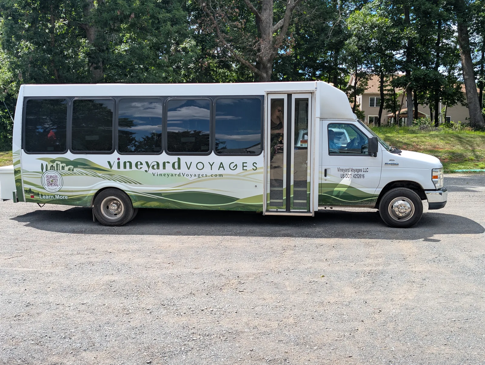 The branded Vineyard Voyages executive coach parked with its passenger door open