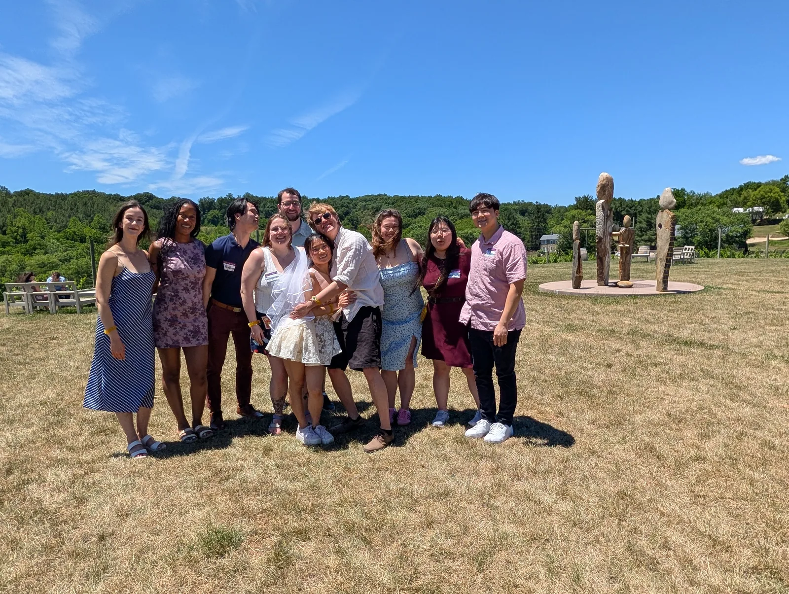 Vineyard Voyages tour group standing in an open vineyard field under a wide blue sky