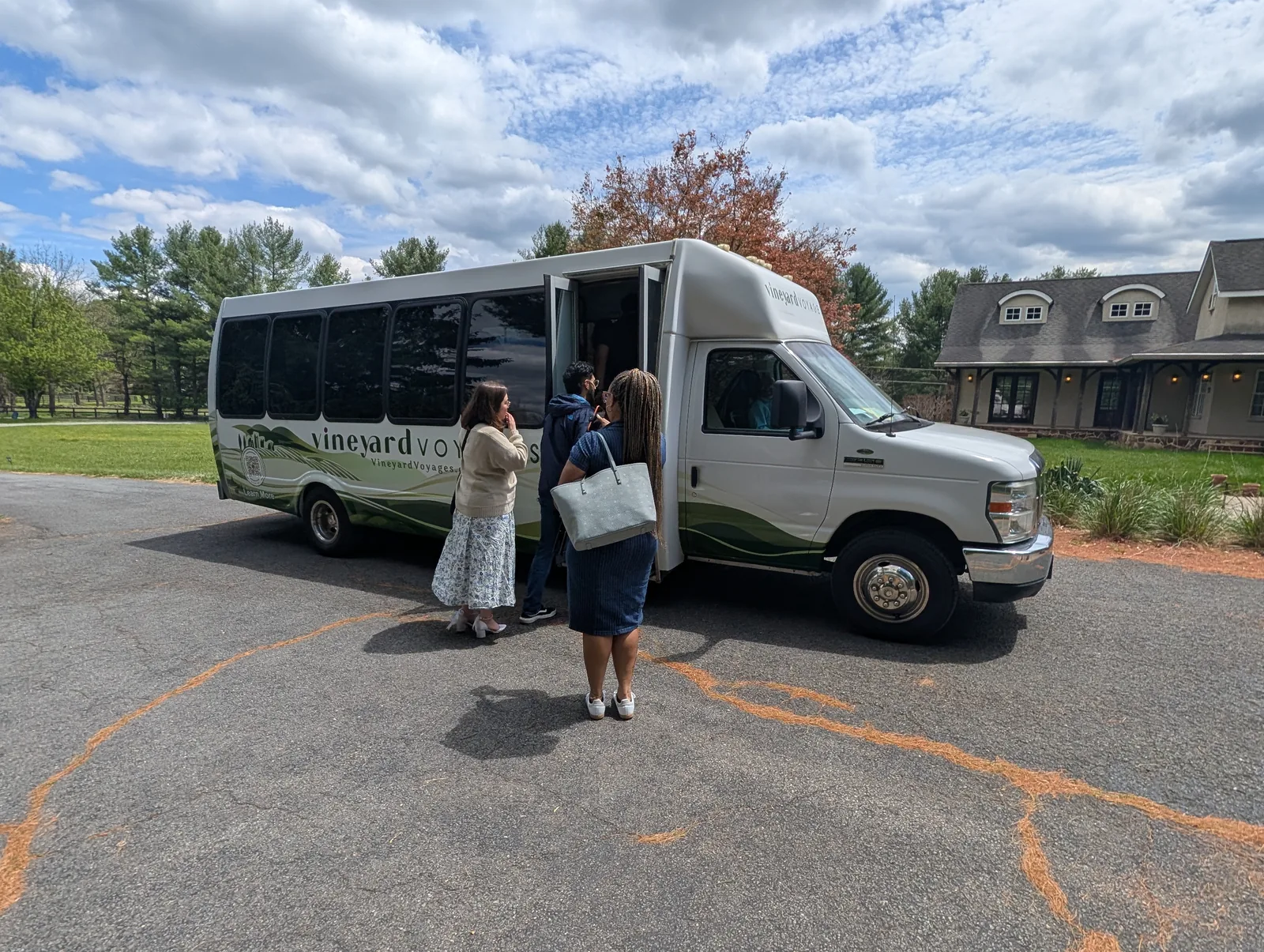 Guests stepping aboard the Vineyard Voyages coach outside a winery