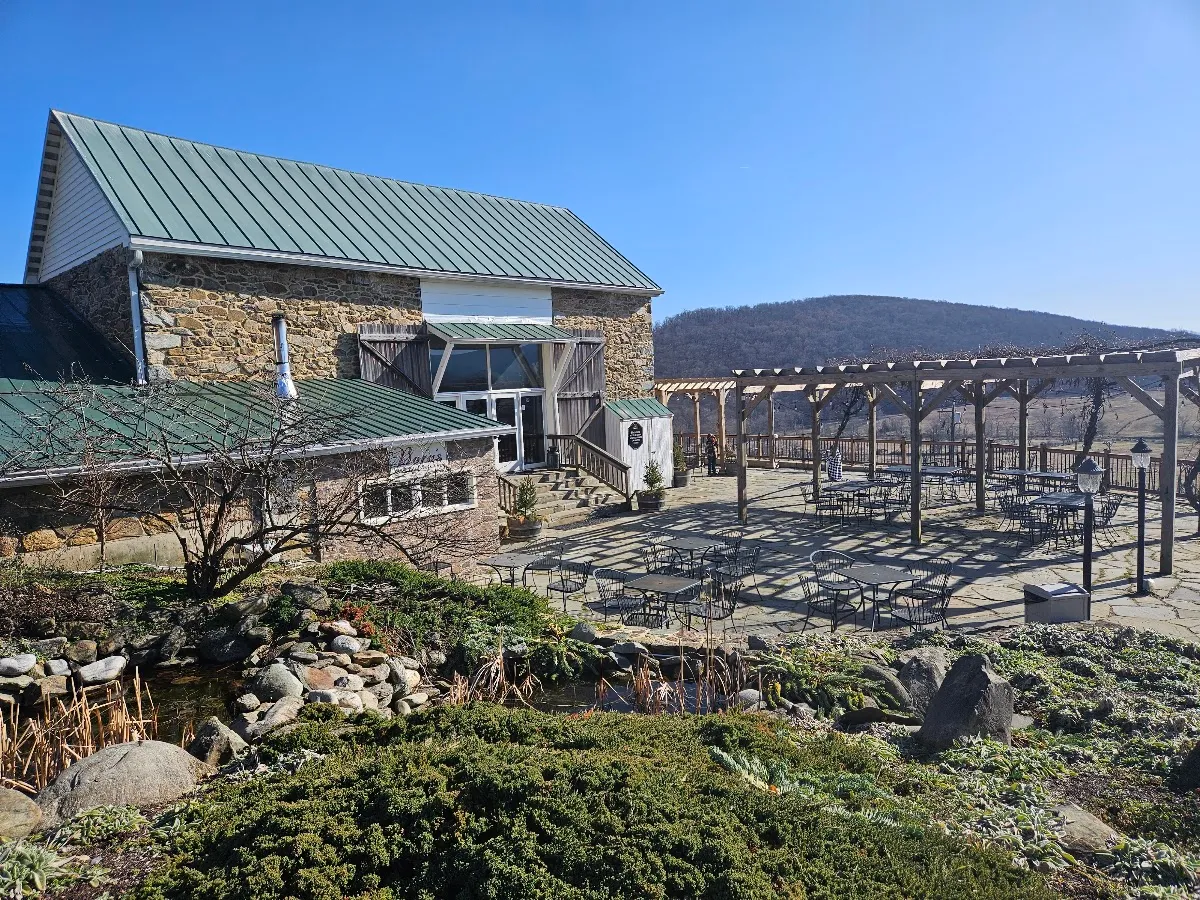 The stone tasting room and terrace at Hillsborough Winery, with the Blue Ridge behind it